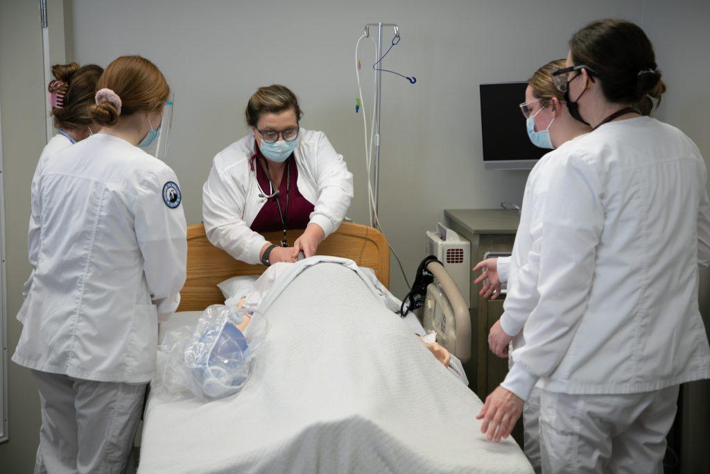 Nursing students work on a simulated patient